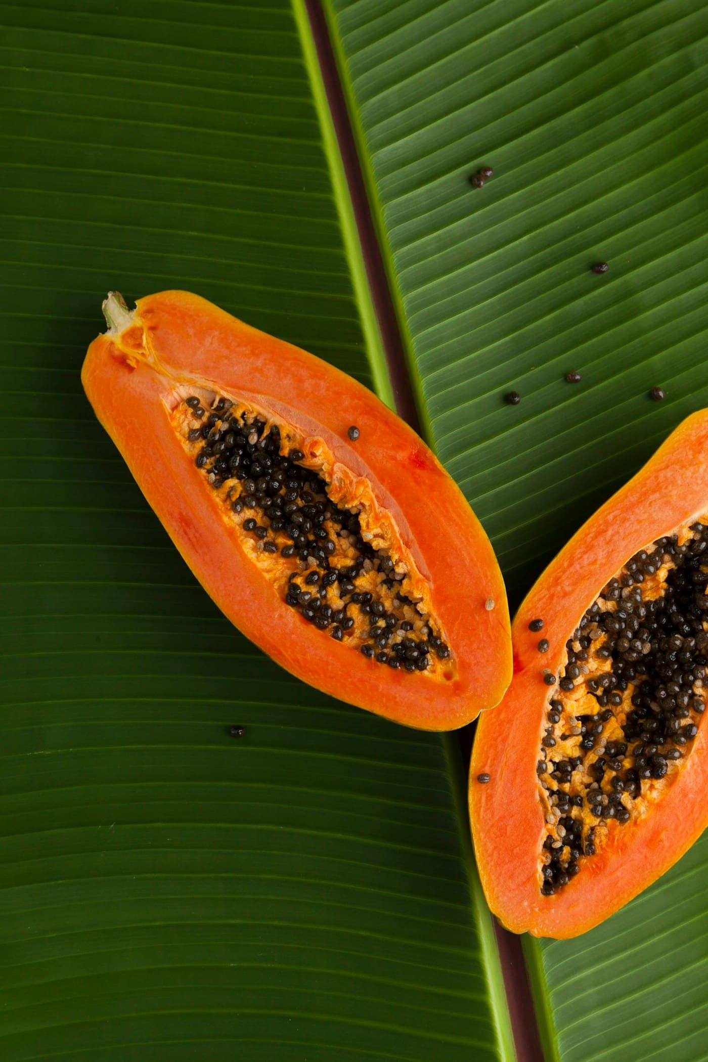 Sliced orange papaya on a banana leaf